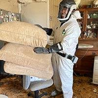 man in a suit holding cushion during a Distressed Property Cleanup in San Francisco.