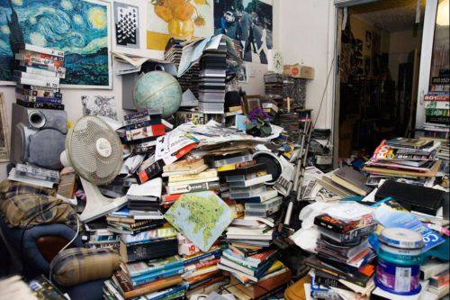 Piles of books, magazines, and junk items for Hoarder Cleanup in Oakland